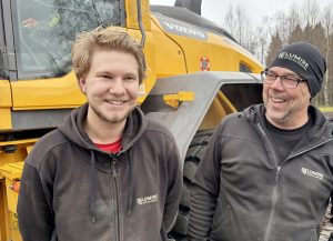 Två manliga drifttekniker står framför en hjullastare