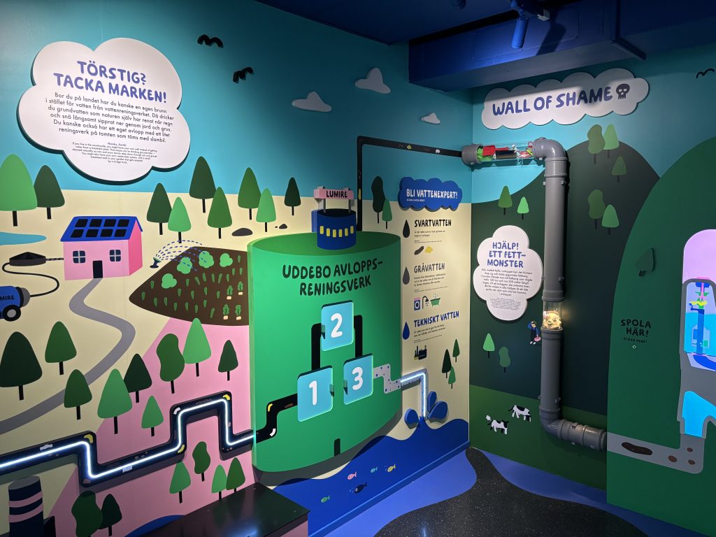 Foto. Väggillustration med text om Uddebo avloppsreningsverk.