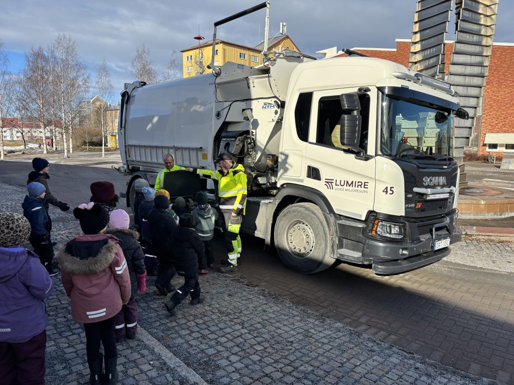 Foto. Personal från Lumire visar ett insamlingsfordon för en förskoleklass.