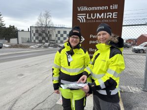 Foto. Två medarbetare på Lumire i varselkläder.
