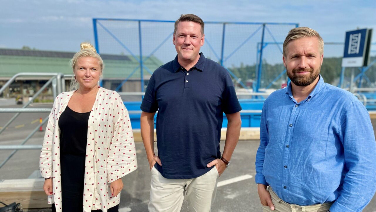Tre personer utomhus på återvininingscentral