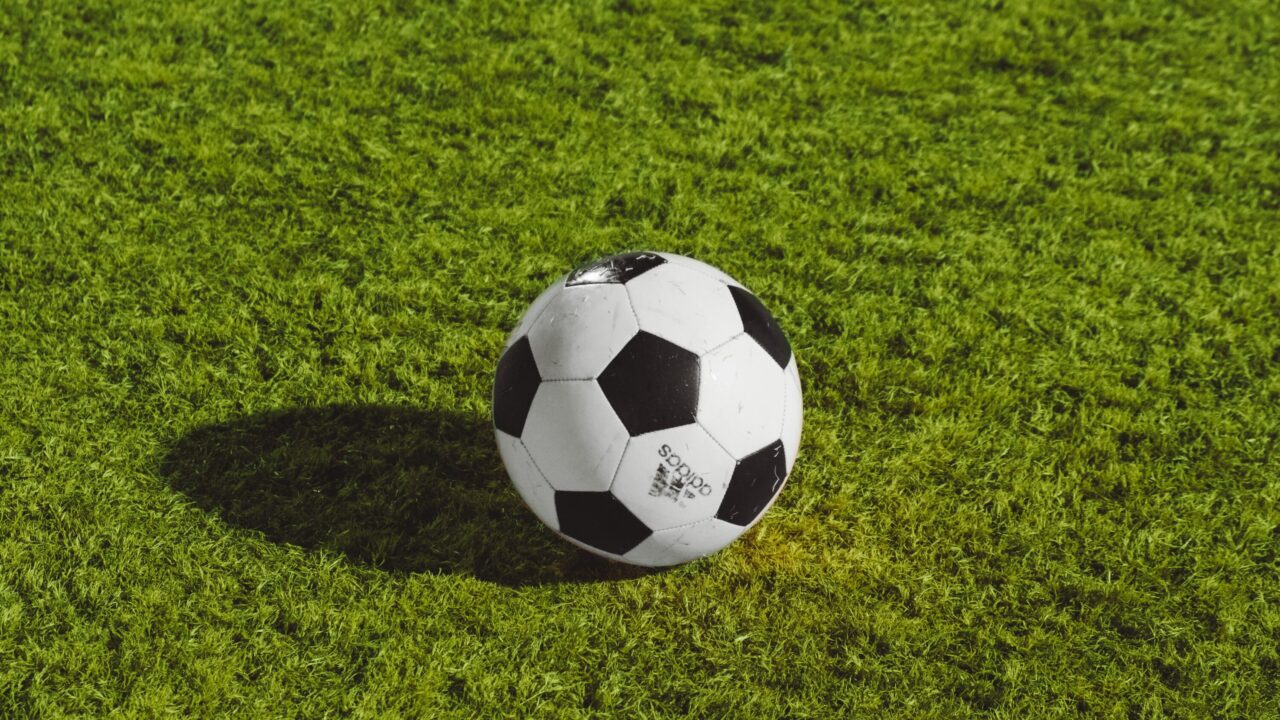 Fotbolssplan med grönt gräs och en fotboll